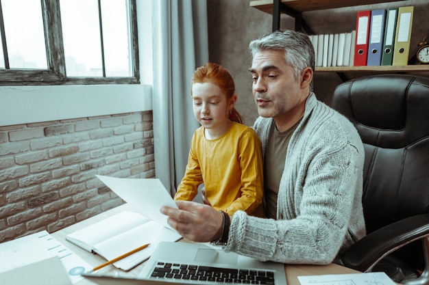 A parent completing tax forms at a desk, with a child sitting nearby, symbolizing the process of claiming the Child Tax Credit and its impact on family finances.