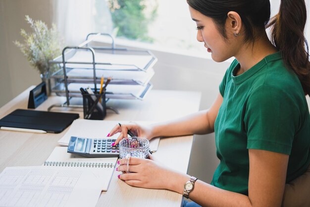 A person using a calculator and a spreadsheet to plan their 401(k) contributions.