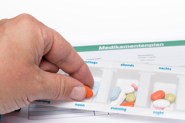 A close-up shot of a hand pointing to a highlighted section in a Medicare guide, with various brochures about senior benefits scattered on the table. Focus is on the Medicare Savings Programs section.